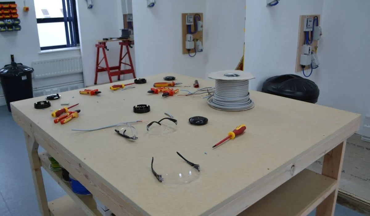 Workbench with tools and safety gear in training room.