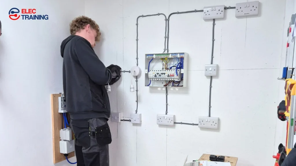 Adult learner completing practical electrical wiring on a training board at an electrical training centre.