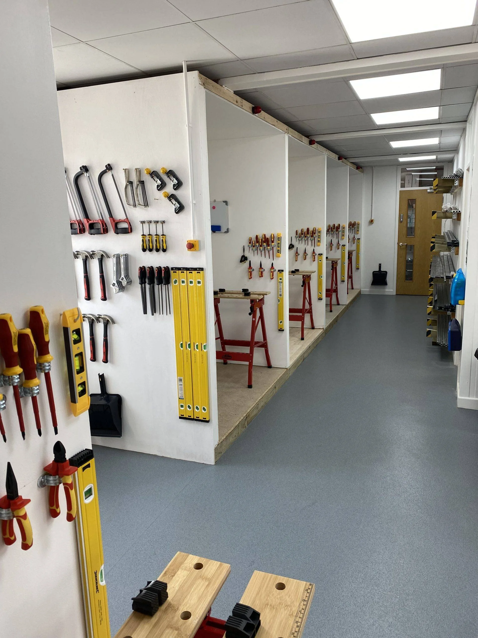 Individual bays and neatly arranged hand tools on the training centre wall
